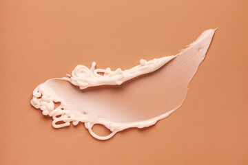 Obraz na płótnie Canvas Cosmetic product cream gel texture smudge on pastel beige background