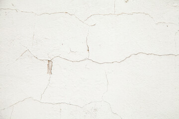 White wall with cracks. Cracks texture on a white abstract background. Cracked plaster on the wall