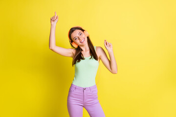 Photo of funny lovely lady dance beaming white smile wear earphones green singlet isolated yellow color background