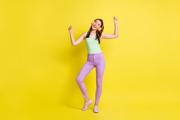 Fototapeta na wymiar Full size photo of young pretty lovely smiling girl dancing in headphones enjoying free time isolated on yellow color background