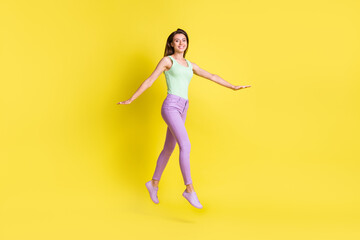 Fototapeta na wymiar Profile photo of funny inspired lady step look camera wear green top pants footwear isolated yellow color background
