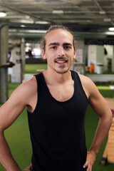 vertical portrait of a trainer posing in his gym