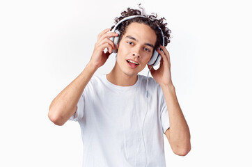Cheerful man with curly hair in headphones listens to music emotions