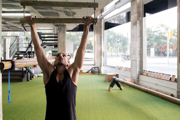 athlete strength training doing pull ups at gym