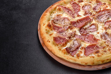 Delicious fresh crispy pizza from the oven with ham, cheese and basil