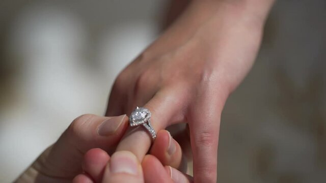 Husband Puts Ring on Wife's Finger Big diamonds  Wedding engagement and proposal for the bride .