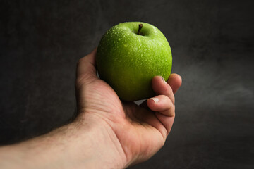 green apple in a man's hand