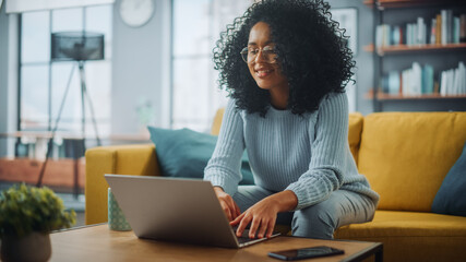 Close Up Portrait of a Beautiful Authentic Latina Female in a Cozy Living Room Using Laptop...
