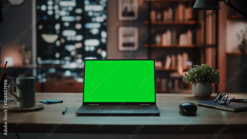 Poster laptop computer with mock up green screen display standing on the table in cozy living room. in the 
