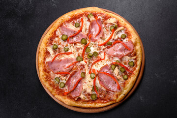Delicious fresh crispy pizza from the oven with ham and Bulgarian pepper