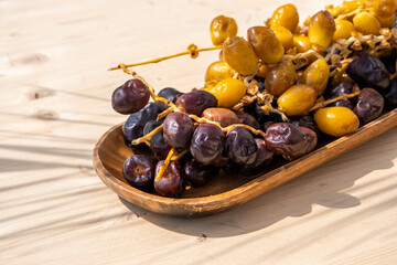 Religious Muslim fasting festival and holy month of Ramadan concept: Many sweet brown and yellow dried date fruits on a wooden plate. Rustical food background with copy space 