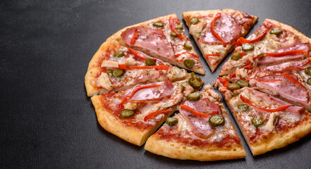 Delicious fresh crispy pizza from the oven with ham and Bulgarian pepper