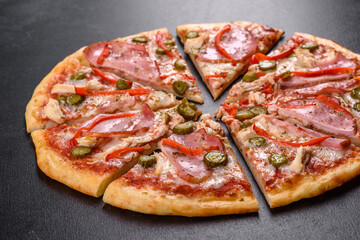 Delicious fresh crispy pizza from the oven with ham and Bulgarian pepper