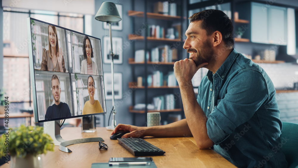 Aufkleber Handsome Caucasian Specialist Making a Video Call on Desktop Computer at Home Living Room while Sitting at Table. Freelancer Working From Home and Talking to Colleagues and Clients Over the Internet.