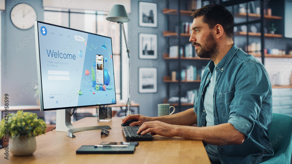Poster Handsome Caucasian Male is Using Desktop Computer that Shows Welcome Page of a Popular Social Network. Freelance Man Working Over the Internet as a Social Network Marketer.