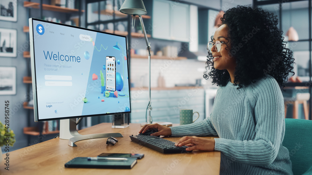 Poster handsome black female is using desktop computer that shows welcome page of a popular social network.
