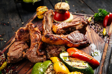 Grilled lamb ribs entrecote with vegetables on a wooden board
