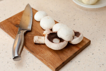 mushrooms laid on a wooden board with a knife