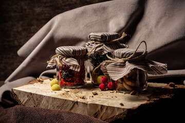 Jars of drying and candy stand on a wooden board on a brown background
