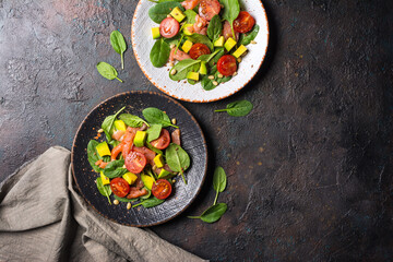 Healthy salad with fresh baby spinach, cherry tomatoes, avocado and salmon fish
