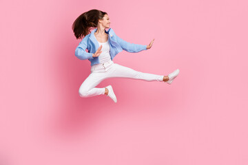 Full length profile side photo of young active woman jump up air ninja pose kick isolated on pastel pink color background