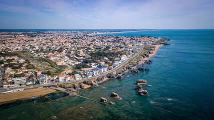 Fototapeta na wymiar Aerial view from a magnificent coastline between cliffs, beaches, clear water and city. That place is called 