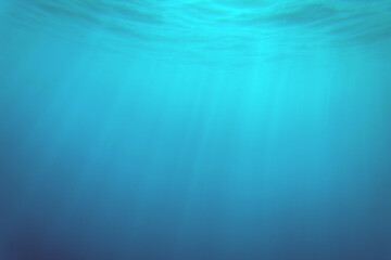 blue ocean surface seen from underwater. waves underwater and rays of sunlight shining through