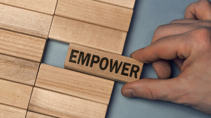 EMPOWER word concept. Close-up wooden piece blocks on the table