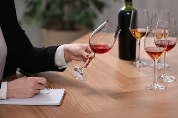 Sommelier tasting different sorts of wine at table indoors, closeup