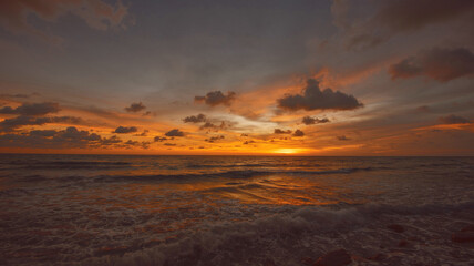 Naklejka na ściany i meble Romantic sky with colorful sunset over the sea background.
