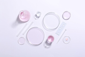 Organic cosmetic product and laboratory glassware on white background, top view