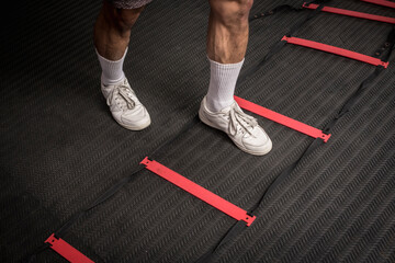 Closeup of footwork on an agility ladder. One foot inside the square. Fitness, cardio and intense...