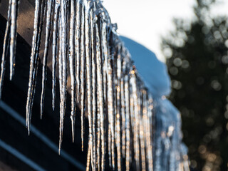 icicle on a snow covered roof in winter