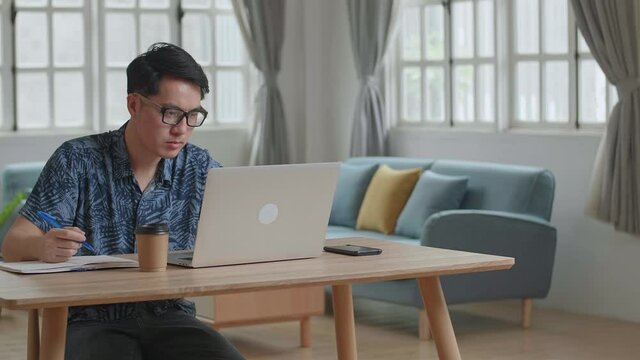 Upset Man Working On Laptop Computer At Home