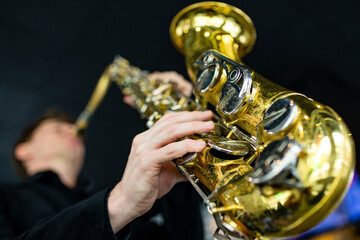 saxophone in hands close-up man in black outfit