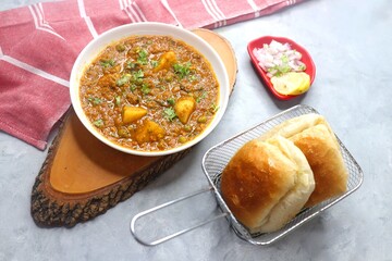Indian famous dish Mutton Kheema Pav or Khima Paav is a minced goat meat curry. Mutton keema cooked with onion, tomatoes, potatoes, green peas along with Indian spices. copy sapce.