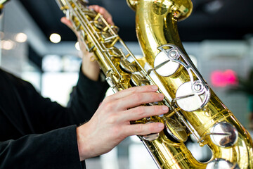 Obraz premium saxophone in hands close-up man in black outfit