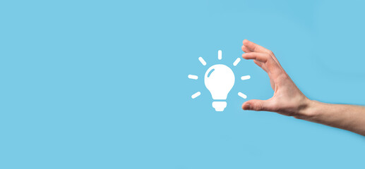 Hand hold light bulb. Holds a glowing idea icon in his hand. With a place for text.The concept of the business idea.Innovation, brainstorming, inspiration and solution concepts