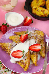 Sweet French toasts served with whipped cream and strawberries