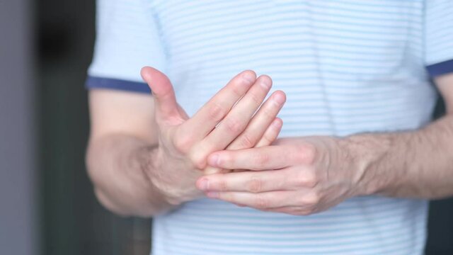 A man massages a joint in his hand. Close up. Carpal tunnel syndrome, arthritis, neurological disease concept. Numbness of the hand. video stock footage. Slow motion, soft focus