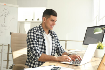 Freelancer working on laptop at table indoors