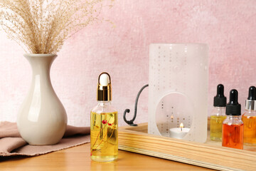 Aroma lamp and essential oils on wooden table