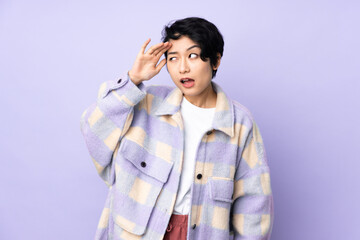 Young Vietnamese woman with short hair over isolated background with surprise expression while looking side