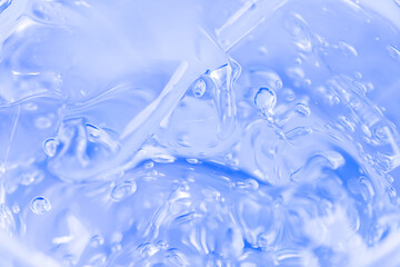 Cosmetic liquid gel serum lubricant hyaluronic acid oxygen bubbles on a blue background. Facial body hair care.