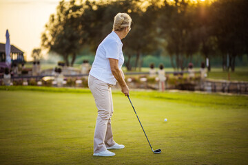 The female golfer prepares to shot.