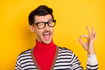 Naklejka premium Photo of young man happy smile blink eye show okey sign deal done cool alright advert advise isolated over yellow color background