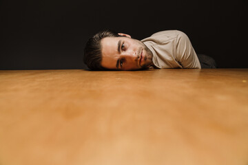Fototapeta na wymiar Upset sad man laying his head on a table indoors