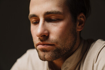 Obraz premium Close up of a sad upset brunette man looking down