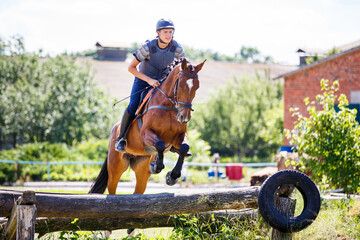 Rider jumps horse over log on cross-country course