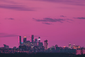 Fototapeta premium Pink sky over city buildings with towers of skyscrapers Moscow city